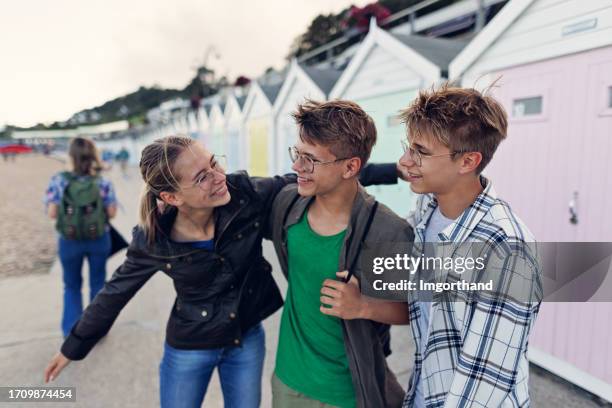 teenagers walking in the town of lyme regis, dorset, united kingdom - boys and girls town stock pictures, royalty-free photos & images