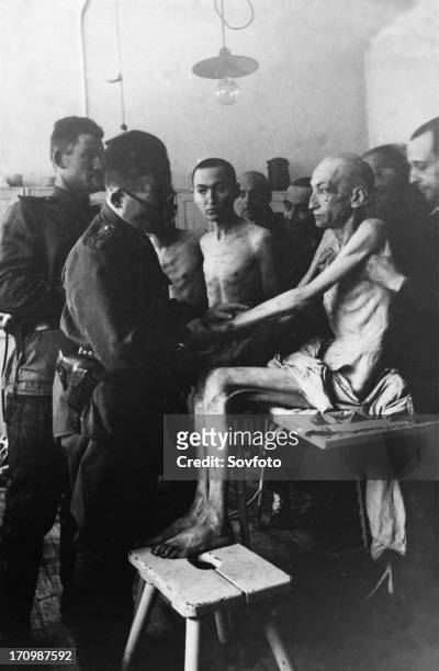 Soviet army surgeon examines an auschwitz concentration camp survivor, vienna engineer rudolf scherm, auschwitz, poland, february 1945.