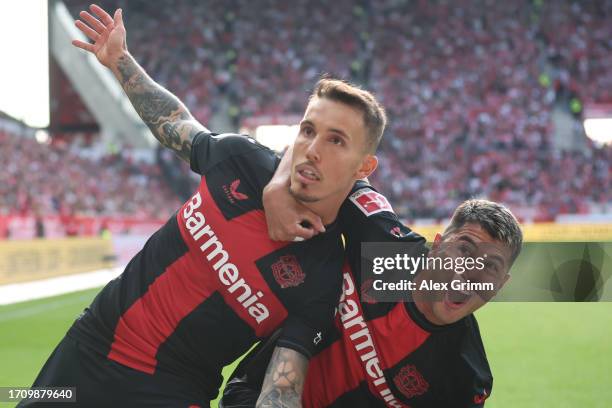 Alex Grimaldo of Bayer Leverkusen celebrates the team's second goal with teammate Exequiel Palacios during the Bundesliga match between 1. FSV Mainz...