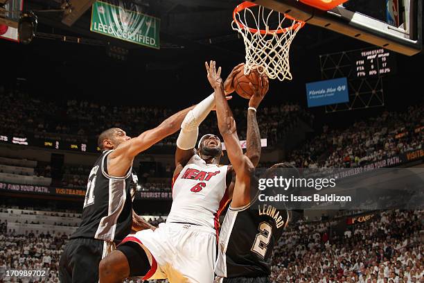 LeBron James of the Miami Heat goes to the basket against Tim Duncan and Kawhi Leonard of the San Antonio Spurs during Game Seven of the 2013 NBA...