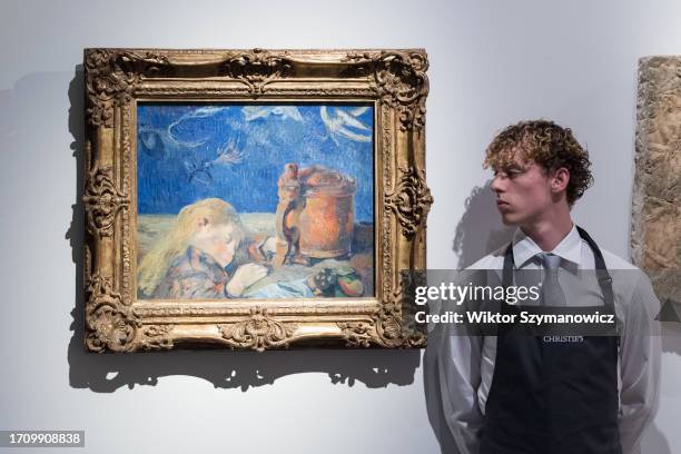 Gallery staff member looks at a painting by Paul Gauguin , Clovis endormi estimate £3 000 5 000, during a photocall at Christie's auction house...