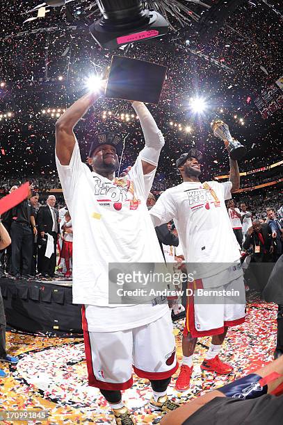 Dwyane Wade holds up the Larry O'Brien Trophy and LeBron James of the Miami Heat holds up the Bill Russell NBA Finals Most Valuable Player Award...
