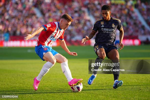 Viktor Tsyhankov of Girona controls the ball whilst under pressure from Jude Bellingham of Real Madrid during the LaLiga EA Sports match between...