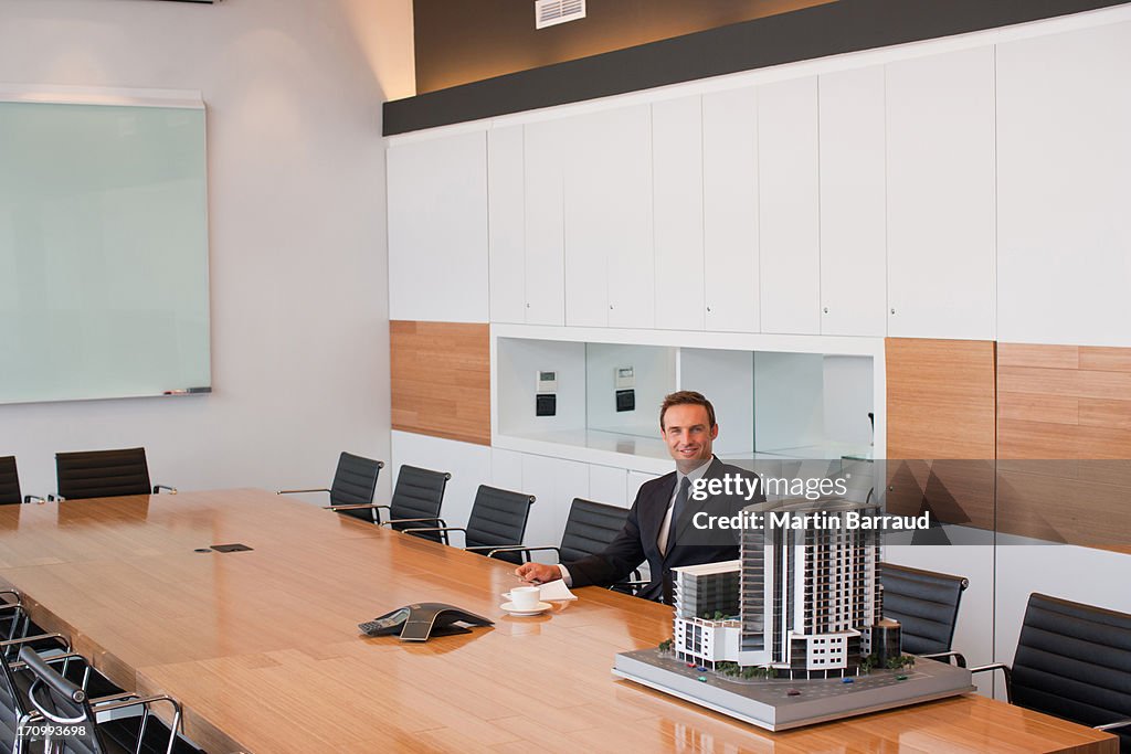 Businessman in conference room with building model