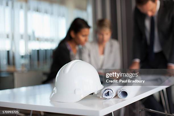 business people reviewing blueprints in conference room - work helmet 個照片及圖片檔