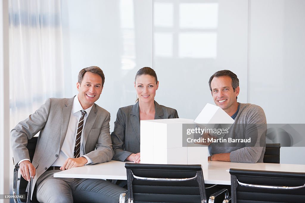 Business people looking at cubes in conference room