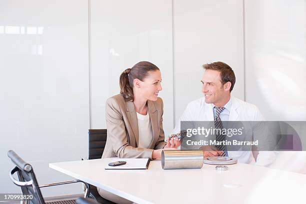 business people looking at circuit board together in conference room - overhemd en stropdas stockfoto's en -beelden