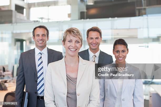 business people standing in office together - four people stockfoto's en -beelden