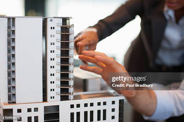 business people looking at model building - model building stockfoto's en -beelden