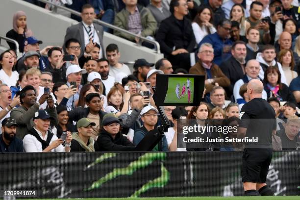 Referee, Simon Hooper watches the Video Assistant Referee before awarding a red card to Curtis Jones of Liverpool during the Premier League match...