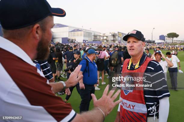 Shane Lowry of Team Europe interacts with caddie of Patrick Cantlay of Team United States Joe LaCava on the 18th green during the Saturday afternoon...