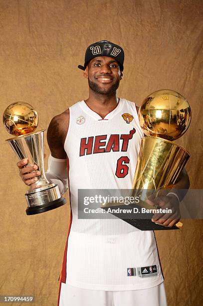 LeBron James of the Miami Heat poses for a portrait with the Larry O'Brien and the Finals MVP Trophy after defeating the San Antonio Spurs in Game...