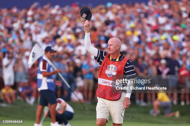 Caddie of Patrick Cantlay of Team United States Joe LaCava, gestures, removing his cap on the 18th green during the Saturday afternoon fourball...