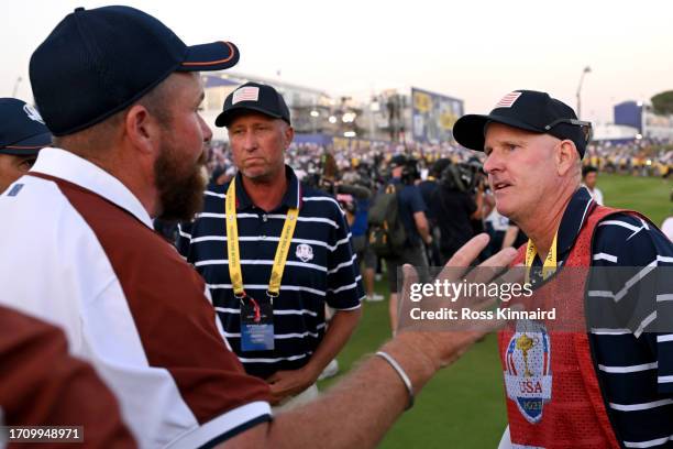 Shane Lowry of Team Europe interacts with caddie of Patrick Cantlay of Team United States Joe LaCava on the 18th green during the Saturday afternoon...