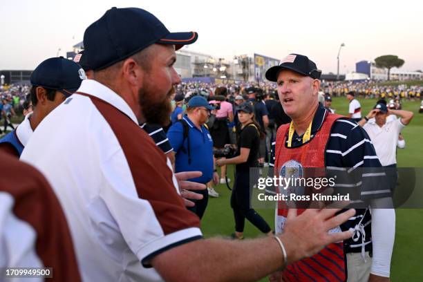 Shane Lowry of Team Europe interacts with caddie of Patrick Cantlay of Team United States Joe LaCava on the 18th green during the Saturday afternoon...