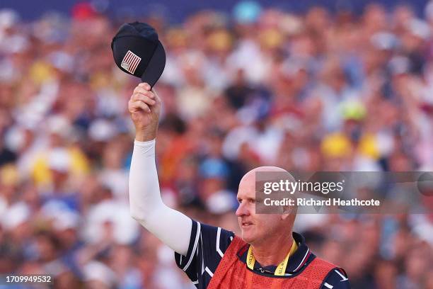 Caddie of Patrick Cantlay of Team United States Joe LaCava, gestures, removing his cap on the 18th green during the Saturday afternoon fourball...