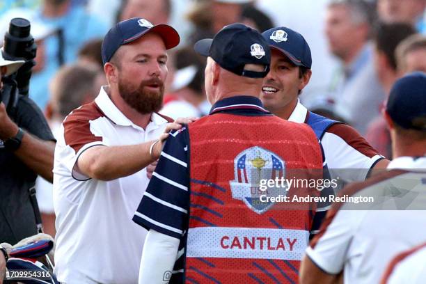 Shane Lowry of Team Europe interacts with caddie of Patrick Cantlay of Team United States Joe LaCava on the 18th green during the Saturday afternoon...