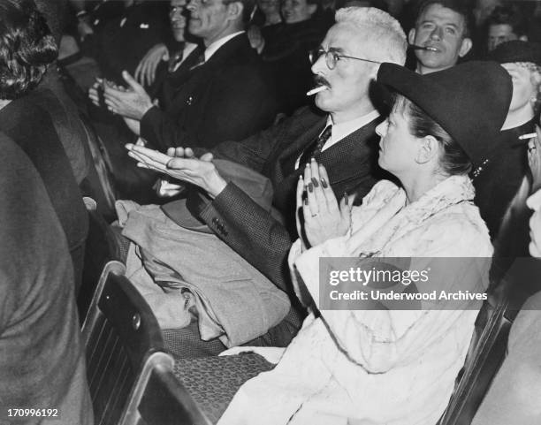 Dashiell Hammett and Dorothy Parker applauding in an audience at an event, 1940.