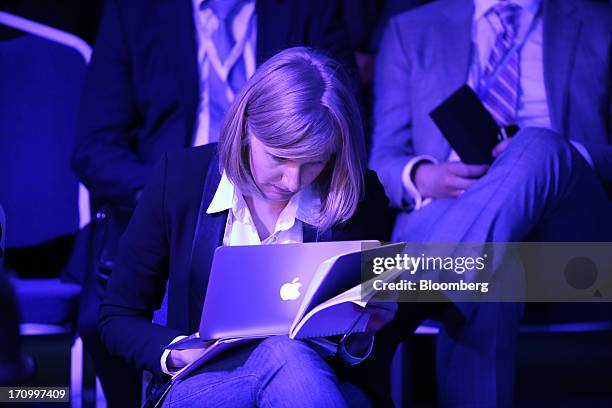 An attendee looks at her Apple Inc. Laptop computer during a conference session on the opening day of the St. Petersburg International Economic Forum...