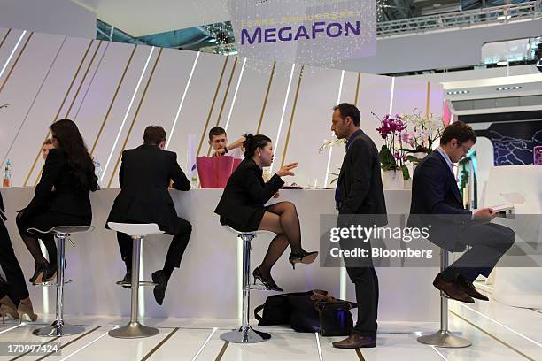Attendees sit at the OAO MegaFon pavilion on the opening day of the St. Petersburg International Economic Forum 2013 in St. Petersburg, Russia, on...