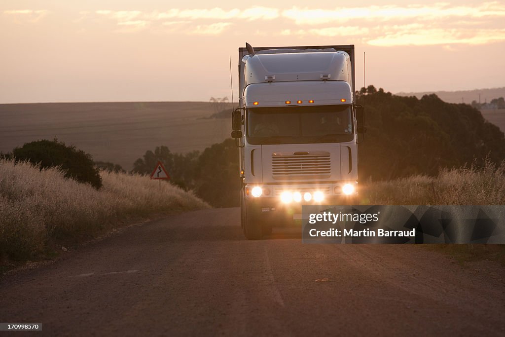 Semi-truck driving in dirt road