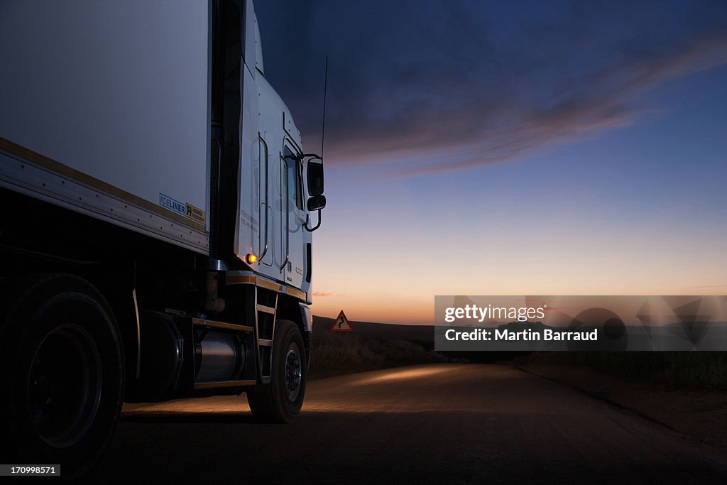 Semi-truck driving on dirt road