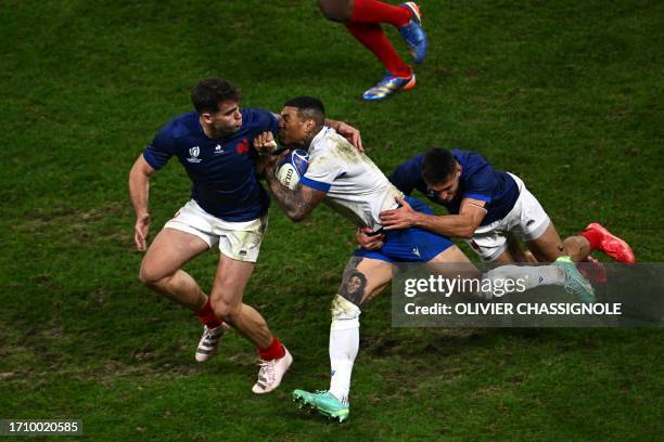 Italy's left wing Monty Ioane is tackled by France's fly-half Matthieu Jalibert and France's scrum-half Baptiste Couilloud during the France 2023...