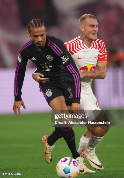 Leroy Sane of Bayern Munich is challenged by David Raum of RB Leipzig during the Bundesliga match between RB Leipzig and FC Bayern München at Red...