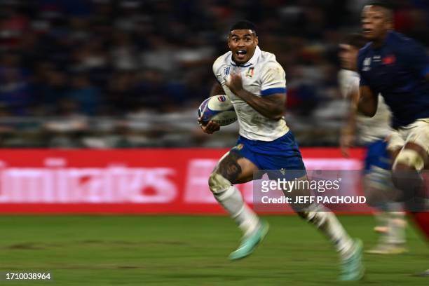 Italy's left wing Monty Ioane runs with the ball during the France 2023 Rugby World Cup Pool A match between France and Italy at the OL Stadium in...