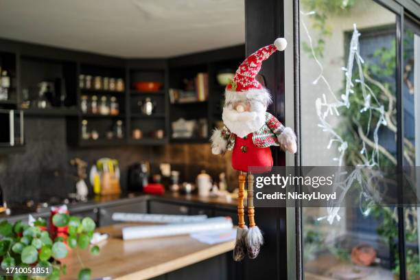 bambola di babbo natale appesa a una finestra durante le vacanze - nicky pende foto e immagini stock