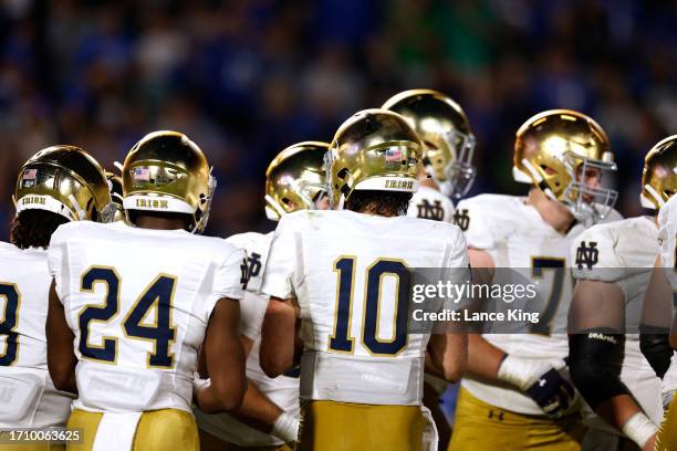 Sam Hartman of the Notre Dame Fighting Irish huddles with teammates during the game against the Duke Blue Devils at Wallace Wade Stadium on September...