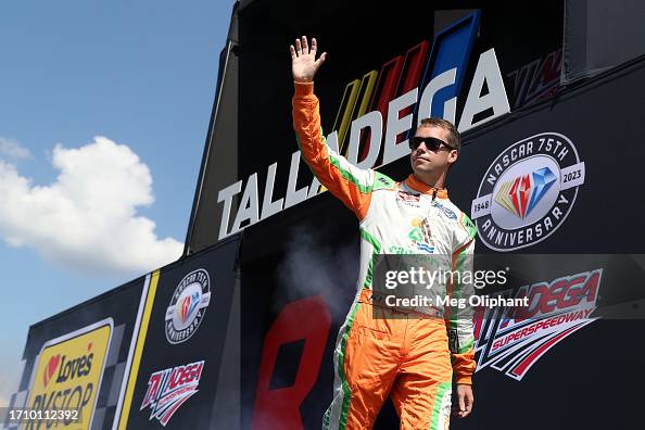 Ron Rhodes Driver Ben Rhodes, driver of the Campers Inn RV Ford, waves to fans as he ...