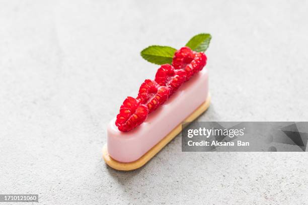 vegan raspberry cream cake on cookie, decorated with fresh slices of raspberries. light gray background. close up - cream cake stock pictures, royalty-free photos & images