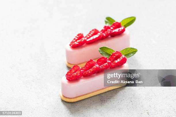 raspberry cream dessert on cookies, decorated with fresh slices of raspberries. light gray background - cream cake stock pictures, royalty-free photos & images