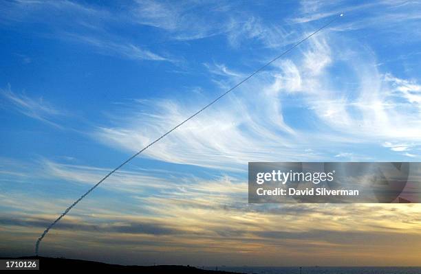 An Israeli Arrow anti-ballistic missile leaves a smoke trail in the evening sky as it flies towards a target after launching from the Palmachim Air...