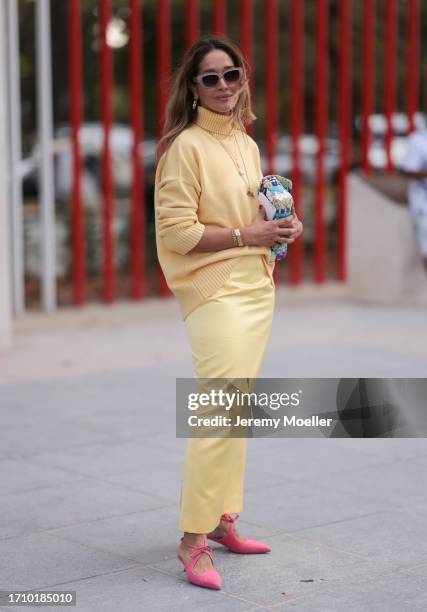 Guest is seen outside Chloe show wearing nude colored Celine sunnies, yellow high neck sweater, colorful Chanel flap bag, yellow pencil skirt, golden...