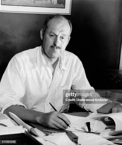 Newspaper columnist and radio commentator Drew Pearson at work at his desk after President Roosevelt had denounced him as a chronic liar in his...