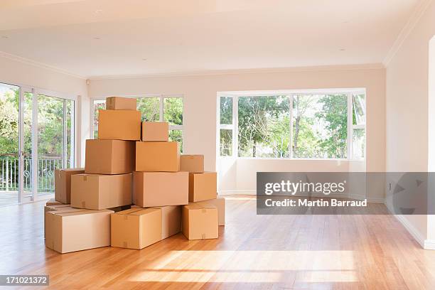 boxes stacked in living room of new house - flytt bildbanksfoton och bilder