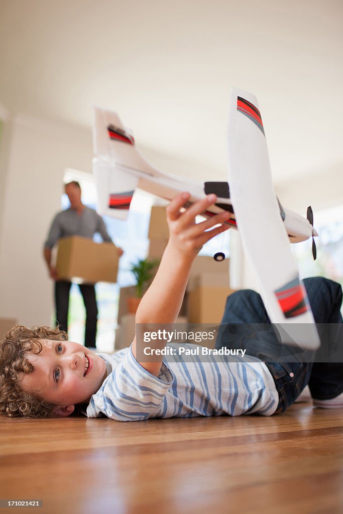 Boy playing with airplane in new home