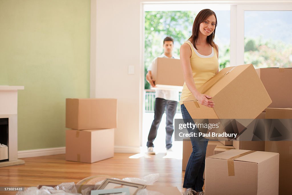 Woman carrying box in her new house