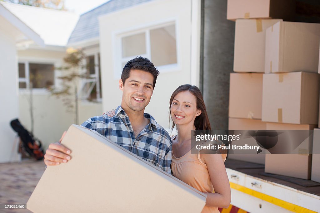 Couple carrying box from moving van