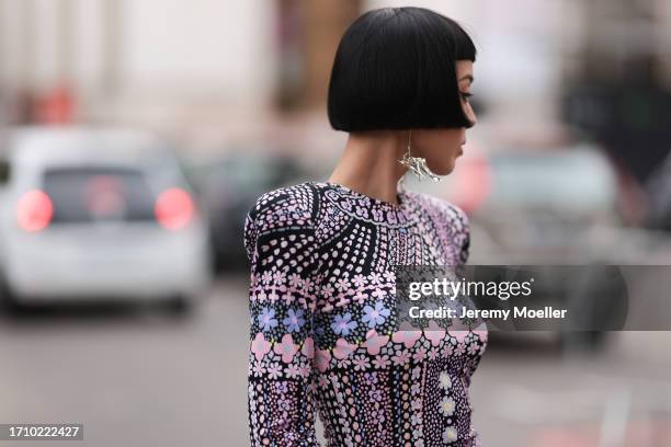 Kiwi Lee is seen outside Leonard Paris show wearing silver earrings, black and pink patterned narrow dress, black plateau boots during the Womenswear...