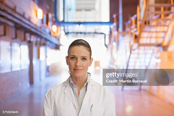 wissenschaftler stehen in fabrik - laborkittel stock-fotos und bilder