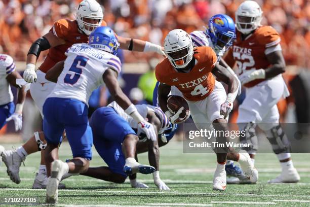 Baxter of the Texas Longhorns runs the ball defended by O.J. Burroughs of the Kansas Jayhawks in the first half at Darrell K Royal-Texas Memorial...