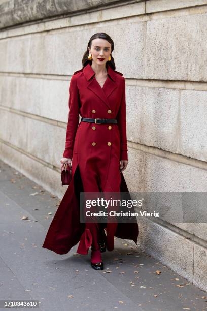 Mary Leest wears red double breasted coat, burgundy bag, black belt outside Ellie Saab during the Womenswear Spring/Summer 2024 as part of Paris...
