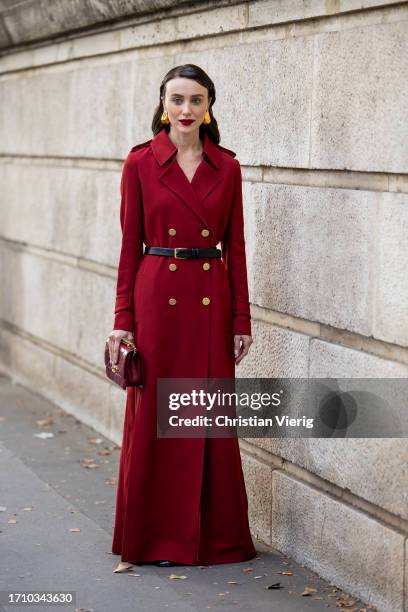 Mary Leest wears red double breasted coat, burgundy bag, black belt outside Ellie Saab during the Womenswear Spring/Summer 2024 as part of Paris...
