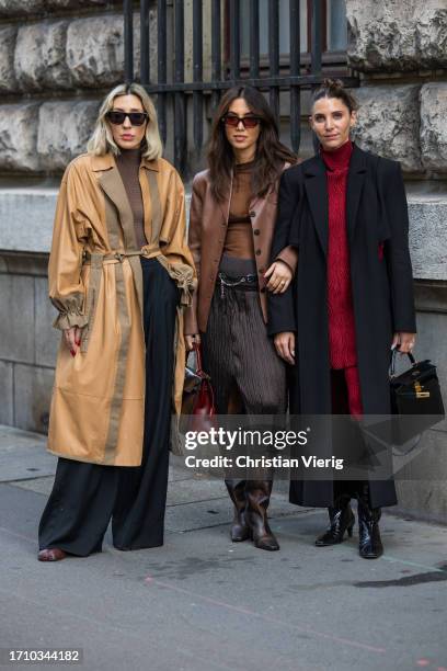 Guest wears beige belted coat and a guest wears black coat, red knit outside Hermes during the Womenswear Spring/Summer 2024 as part of Paris Fashion...