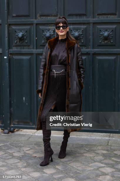 Gabrielle Caunesil Pozzoli wears brown shearling coat, pleated dress, over knees boots, sunglasses outside Hermes during the Womenswear Spring/Summer...