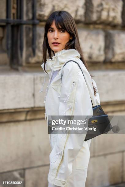 Leia Sfez wears white cropped jacket, pants, black jacket, transparent shoes outside Hermes during the Womenswear Spring/Summer 2024 as part of Paris...