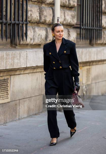 Nataly Osmann wears black double breasted blazer, gloves, burgundy bag, pants outside Hermes during the Womenswear Spring/Summer 2024 as part of...